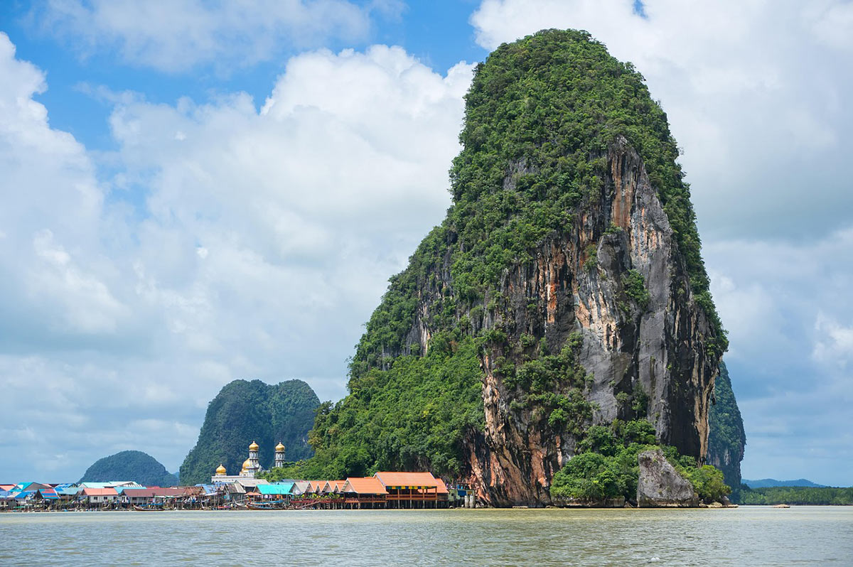 A luxury wooden cruise boat sailing through the emerald waters and limestone karsts of Lan Ha Bay - the ultimate Lan Ha Bay cruise gui